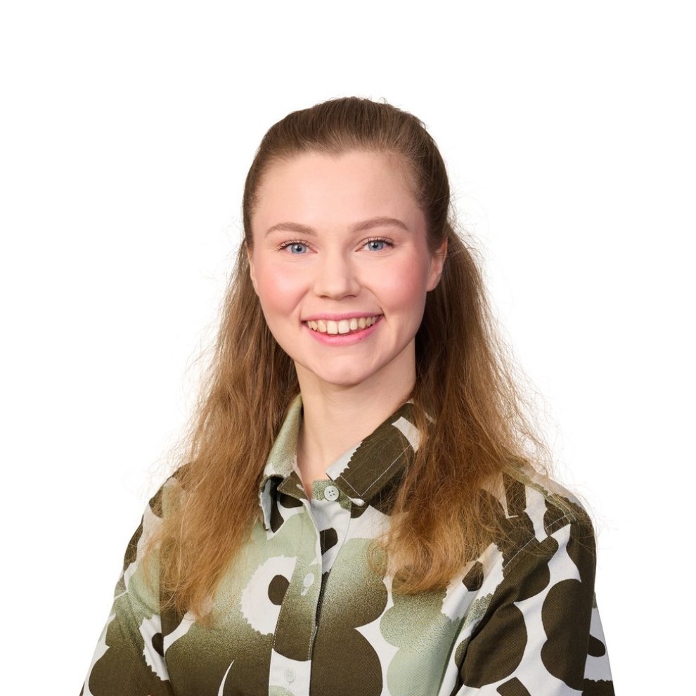 Pitkähiuksinen nuori nainen vihertävässä Marimekon mekossa