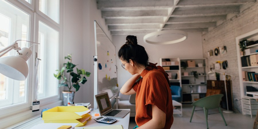 Nainen tekee yksin töitä toimistossa